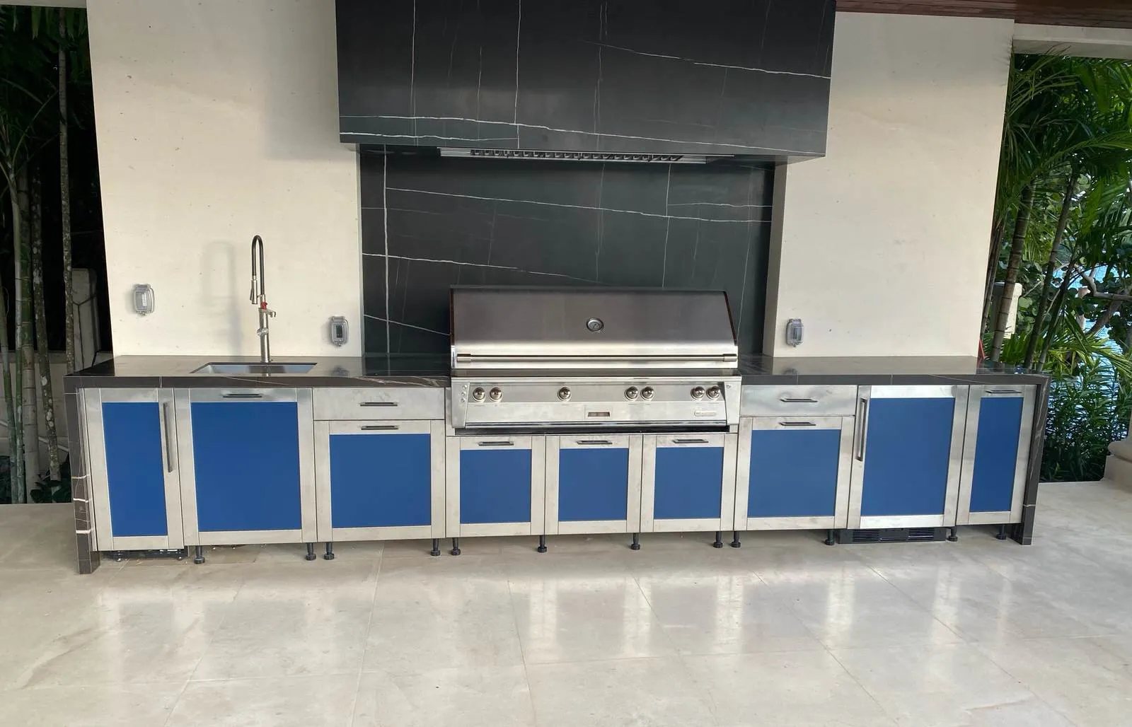 Long stainless outdoor kitchen with blue powder-coated doors on a covered terrace, Star Island